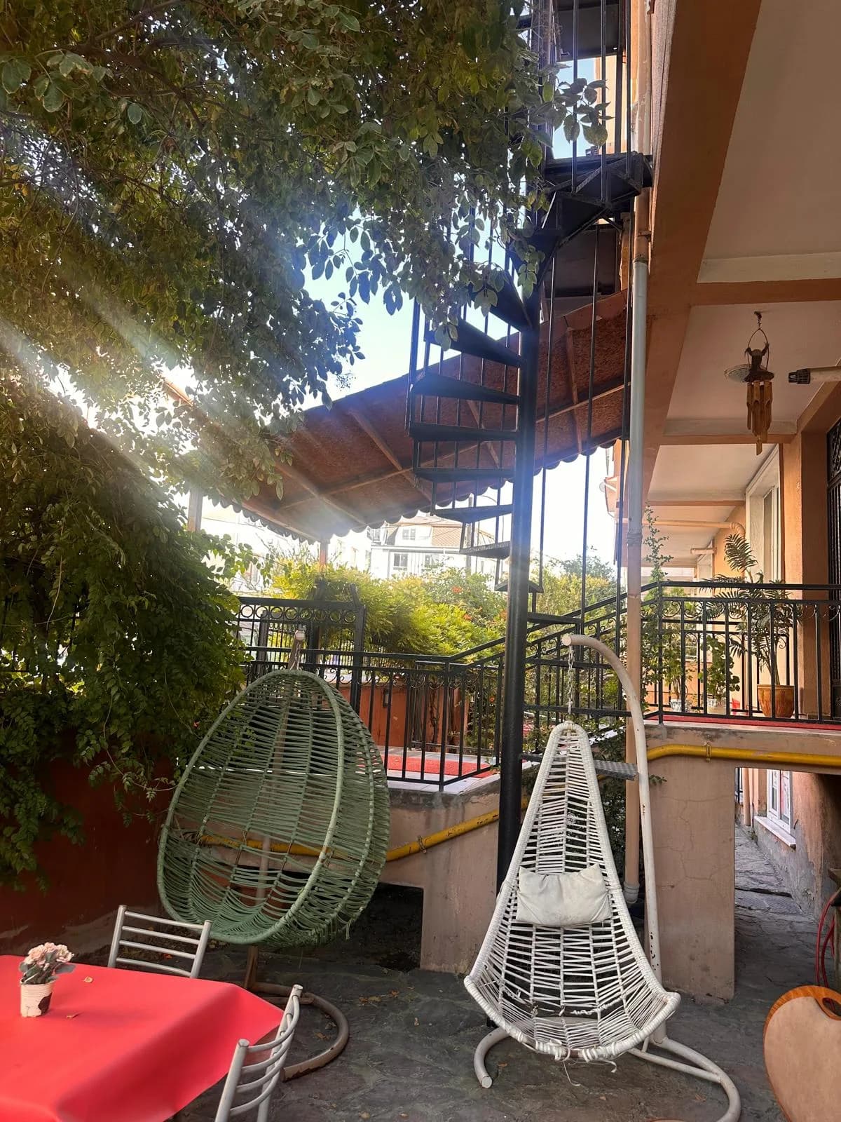 Elit Konaklama bahçesinde salıncak koltuklar, yeşil alan ve bina çevresi